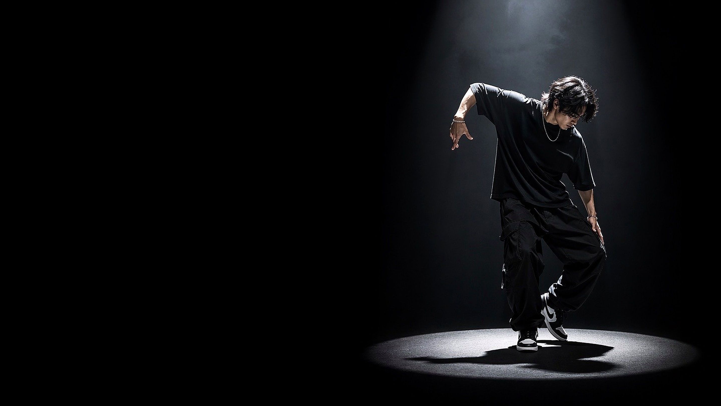 スポットライトの中で踊る男性ダンサーのダンス発表会動画撮影向けヒーロー画像